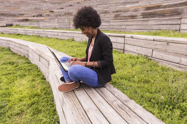 Muda afro wanita Amerika menggunakan laptop. Latar belakang hijau. Casua — Stok Foto