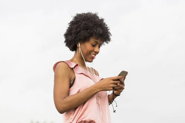 Happy young beautiful afro american woman listening to music in — Stok Foto