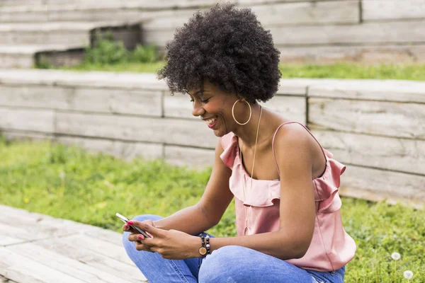 Retrato ao ar livre de uma bela jovem afro-americana em su Fotos De Bancos De Imagens