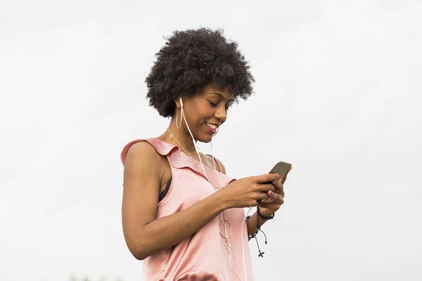 Jovem feliz bela mulher afro-americana ouvindo música em Imagens De Bancos De Imagens Sem Royalties