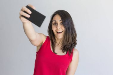 Whit üzerinde akıllı telefon ile bir selfie alarak mutlu güzel kadın