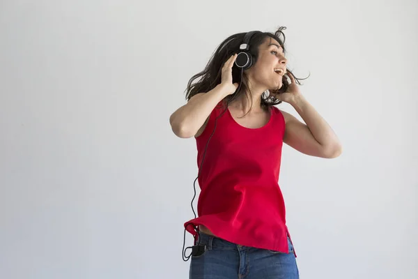 Wanita muda yang cantik mendengarkan musik di telepon genggamnya — Stok Foto