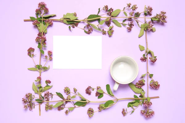 Decorative frame of oregano plants with sheet of paper and cup on lilac background