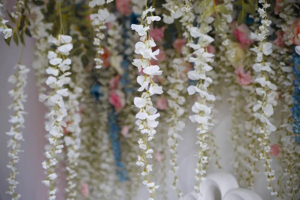 Bunch of flowers of artificial wisteria of white color.