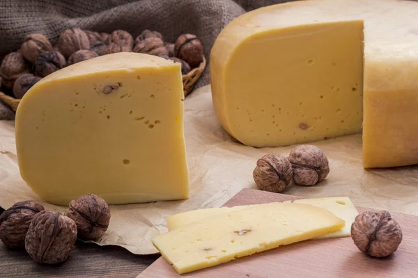 Ruota di formaggio con noci sul tavolo — Foto Stock