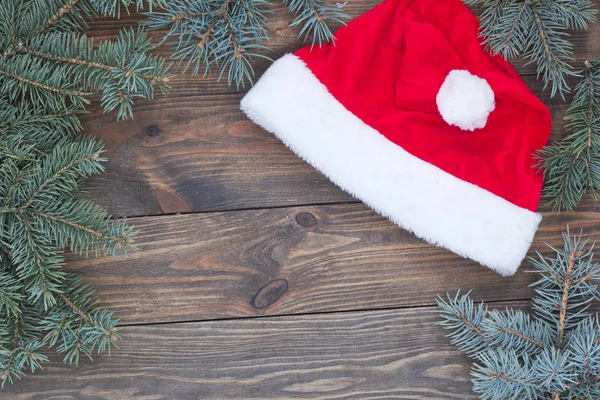 Шляпа Санта-Клауса на столе, рождественский свиток — стоковое фото