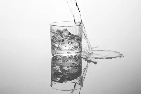 Alcohol vertiendo en vidrio aislado en blanco — Foto de Stock