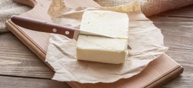 Tahta tahta tahta ve bir parça tereyağı. Köy masasında bıçak.