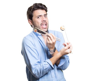 Genç adam beyaz arka planda suşi yiyor.