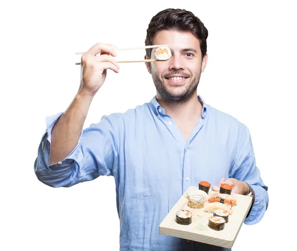 Jovem comendo sushi no fundo branco — Fotografia de Stock