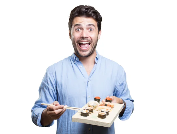 Jovem comendo sushi no fundo branco — Fotografia de Stock