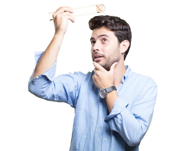 Jovem comendo sushi no fundo branco — Fotografia de Stock