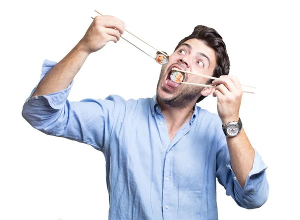 Jovem comendo sushi no fundo branco — Fotografia de Stock