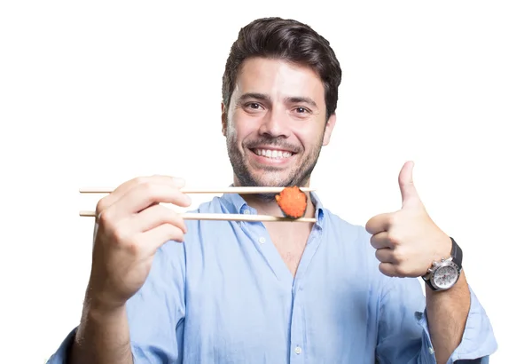 Young man eating sushi on white background — Stock Photo, Image
