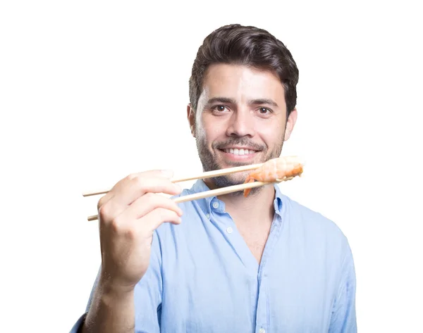 Joven comiendo sushi sobre fondo blanco — Foto de Stock