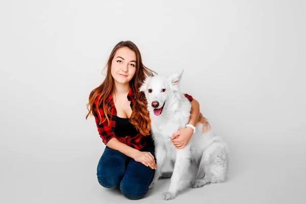 Portrait of a young teenager girl with her dog in studio on a white background — Stock Photo, Image