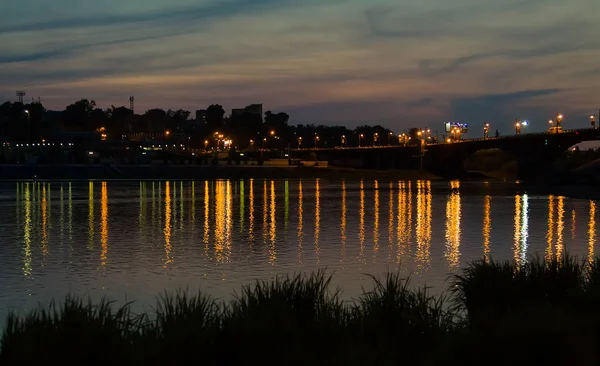 Paesaggio urbano con fiume dopo il tramonto — Foto Stock