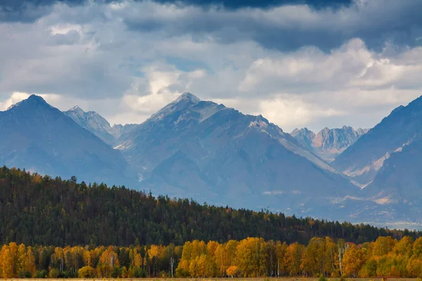 Bergen met herfstbos aan de voorkant en dramatische wolken — Stockfoto