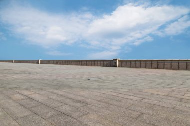 Asfalt kaldırımlar ve kare döşemeler mavi gökyüzünün altında ve 