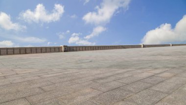 Asfalt kaldırımlar ve kare döşemeler mavi gökyüzünün altında ve 