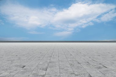 Asfalt kaldırımlar ve kare döşemeler mavi gökyüzünün altında ve 