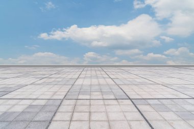 Asfalt kaldırımlar ve kare döşemeler mavi gökyüzünün altında ve 