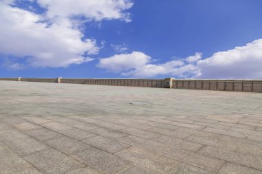 Asfalt kaldırımlar ve kare döşemeler mavi gökyüzünün altında ve 