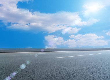 Asfalt kaldırımlar ve kare döşemeler mavi gökyüzünün altında ve 