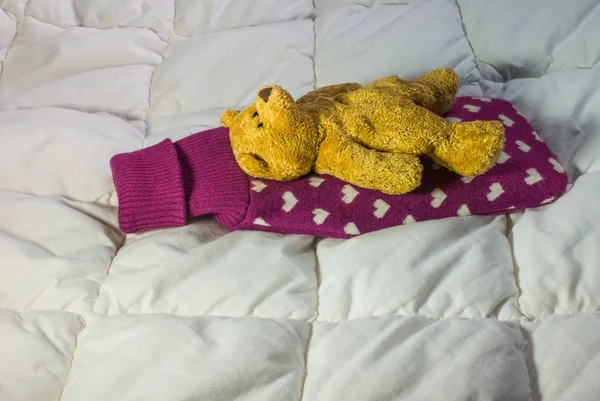 Oso de peluche enfermo acostado con una botella de agua caliente en la espalda — Foto de Stock