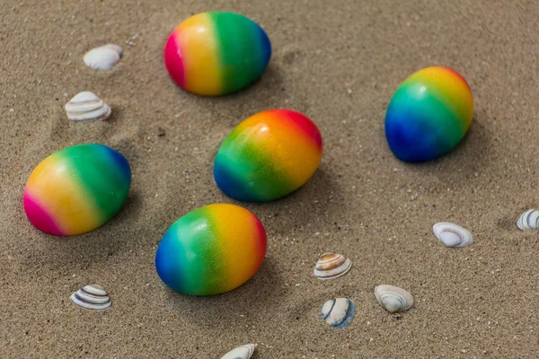 Concetto pasquale, cinque uova colorate e scelld sulla spiaggia  . — Foto Stock