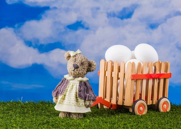 Пасхальная сцена с медведем и тележкой с яйцами — стоковое фото