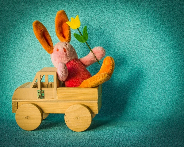 Coelho da Páscoa com uma tulipa viajando em um carro de madeira . — Fotografia de Stock