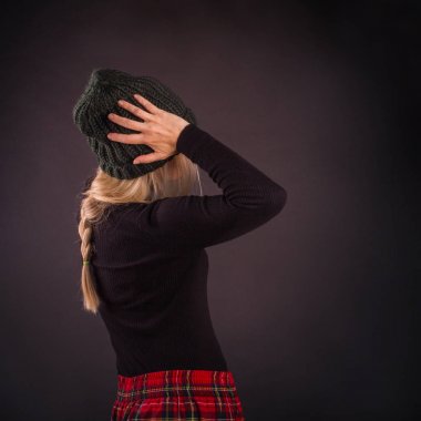 Genç kadın bir tırpan ile büyük bir örme şapka kafasına tutar..