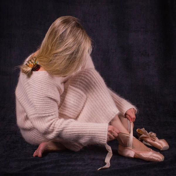 Katta oturan balet ve bale ayakkabıları koyar