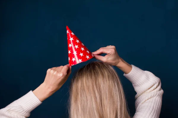 Festa e celebração.Mulher segurando chapéu vermelho de papel com estrelas em — Fotografia de Stock
