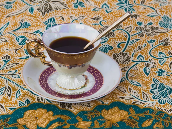 A Cup of Coffee on Asian Ornamental Backgroundon. — Stock Photo, Image