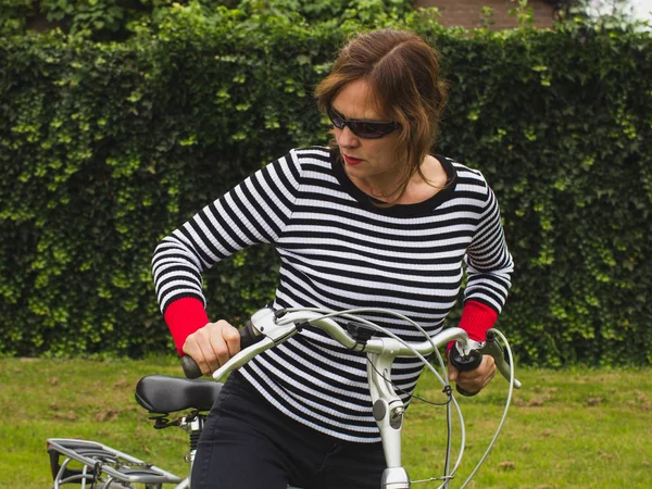 Moderne, vitale Radfahrerin mit gestromtem Pullover. — Stockfoto