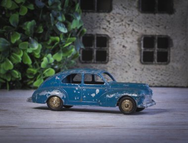 50'li hasarlı araba modeli mavi renktir evin yakınına