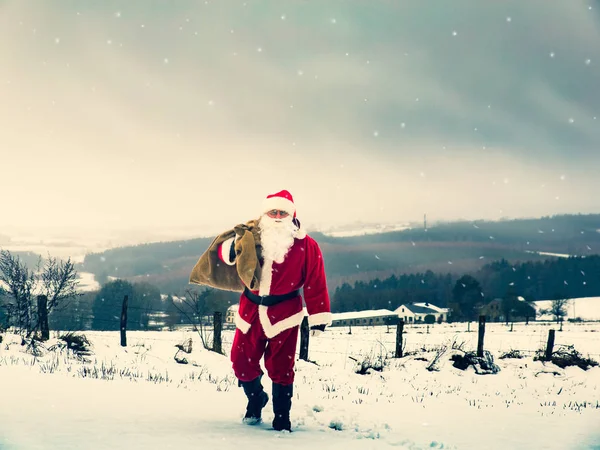 Babbo Natale con una borsa piena di regali di Natale è camminare alo — Foto Stock