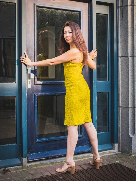 Femme Asiatique Déterminée Dans Une Robe Jaune Debout Devant Entrée — Photo