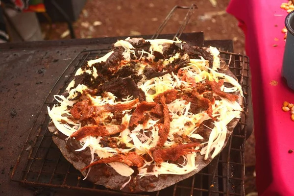 Tlayuda se cocina en la estufa o anafre en México, deliciosa tortilla enorme con frijoles, queso Oaxaca y carne seca —  Fotos de Stock