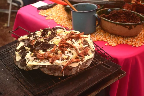 Tlayuda se cocina en la estufa o anafre en México, deliciosa tortilla enorme con frijoles, queso Oaxaca y carne seca — Foto de Stock