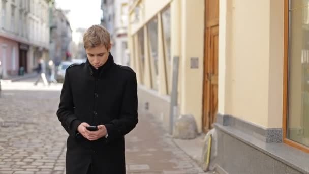 Чоловік друкує на мобільному телефоні — стокове відео