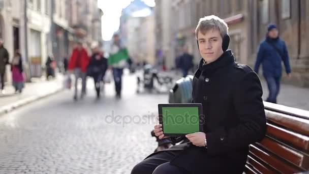 Чоловік сидить з планшетом — стокове відео