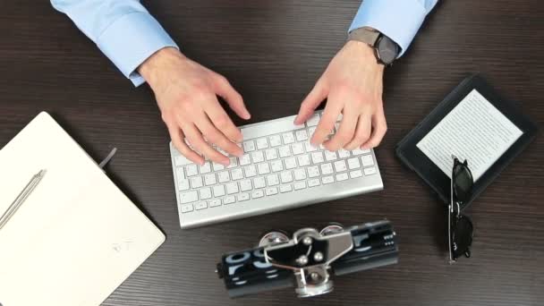 Vista superior del hombre de negocios escribiendo en un teclado en una mesa marrón — Vídeos de Stock