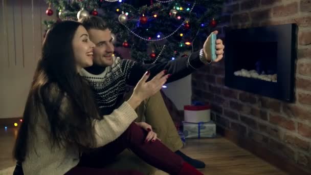 O casal se reuniu em torno de uma árvore de Natal, usando um tablet — Vídeo de Stock