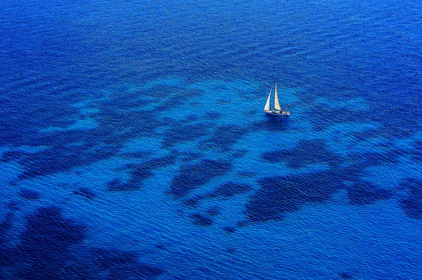 Вид на море с белым парусником . — стоковое фото