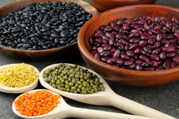 Různé druhy fazole a čočka v dřevěné misce. — Stock fotografie