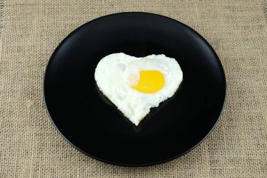 Sahanda yumurta siyah plaka üzerinde kalp şeklinde.