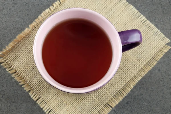 Cup of black tea on sackcloth. — Stock Photo, Image